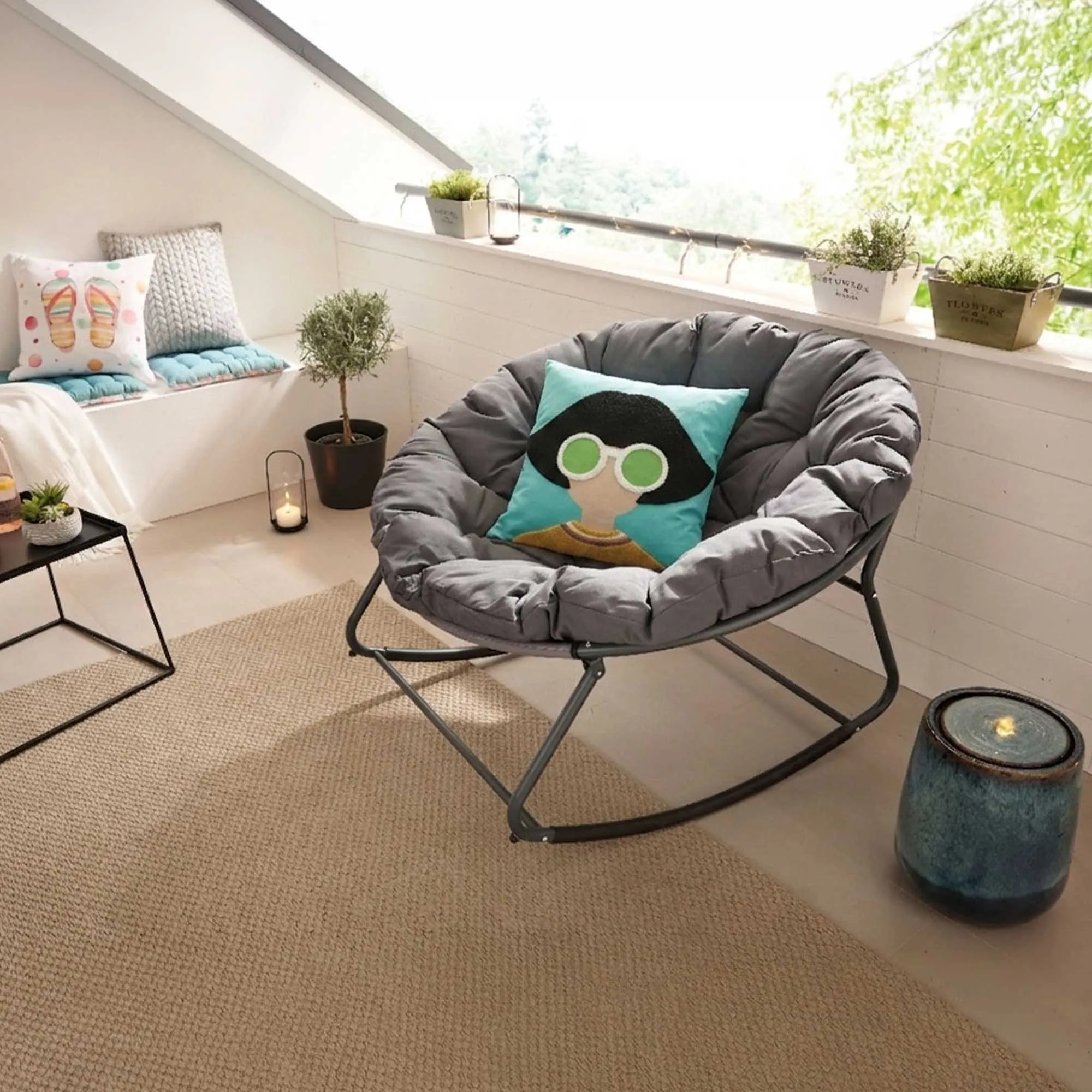 Wohninspiration: gemütliche Leseecke mit grauem Schaukelstuhl, Kissen, Pflanze und Teppich