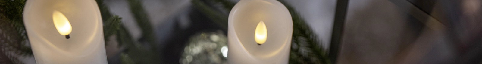 LED‑Leuchtdeko: weiße LED‑Kerzen zwischen Tannengrün als stimmungsvolle Dekoration